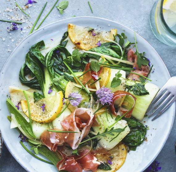 Pak Choi-Salat mit Prosciutto und Zitronen-Ingwer-Dressing auf einem Teller