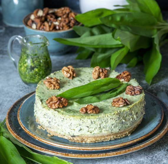 Bärlauch-Käsekuchen auf Teller und blauem Hintergrund