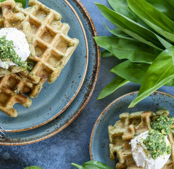 Bärlauchwaffeln mit Frischkäse-Topping auf einem Teller
