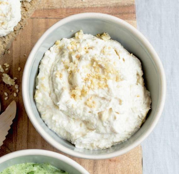 Zwei Aufstriche in Schälchen auf einem Holzbrett