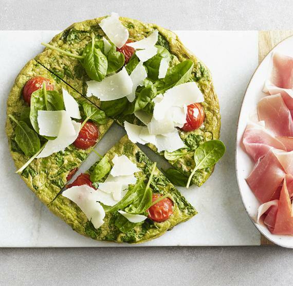 Spinat-Frittata auf einem Teller mit Schinken daneben