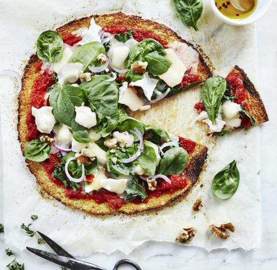 Pizza aus Blumenkohl mit Gemüse auf einem Tisch