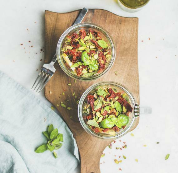 Gläser mit Salat auf Brett