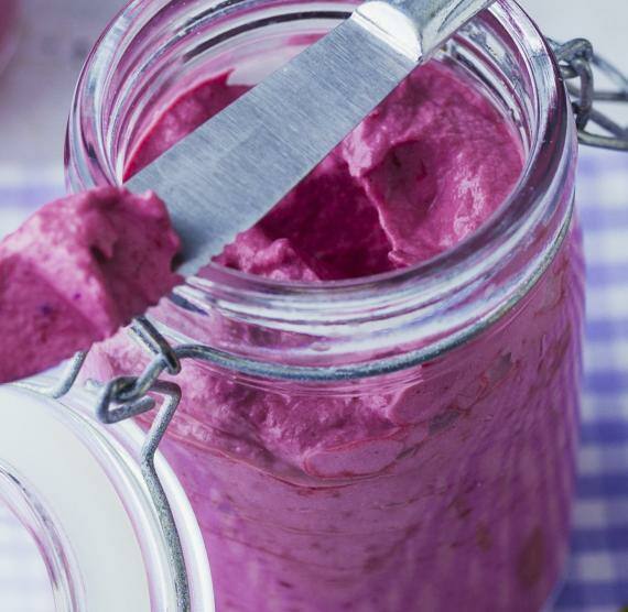 Brombeer-Frischkäse-Aufstrich in kleinen Gläsern mit Brotmesser.