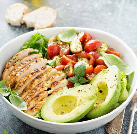 Avocado-Hähnchen-Bowl in einer Schüssel mit Besteck.