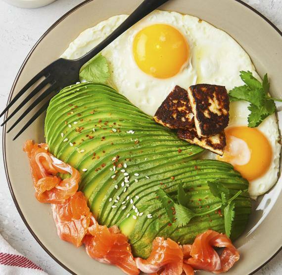 Avocado, Spiegelei und lachs auf einem Teller