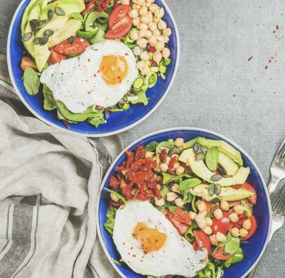 Gemüse und Spiegeleier in blauen Schalen
