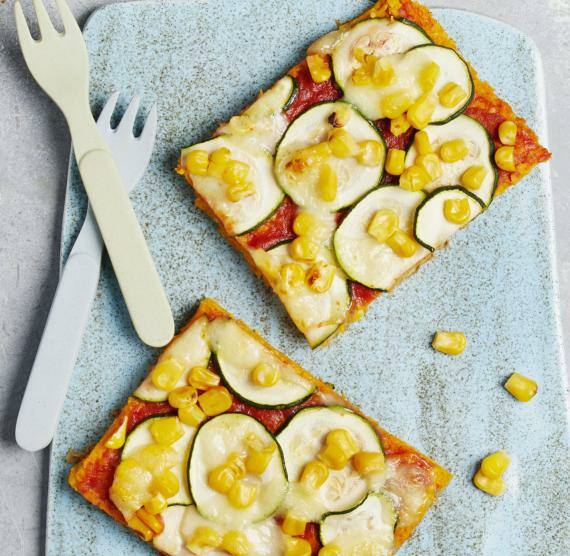 Kürbispizza mit Mais auf einem Brett