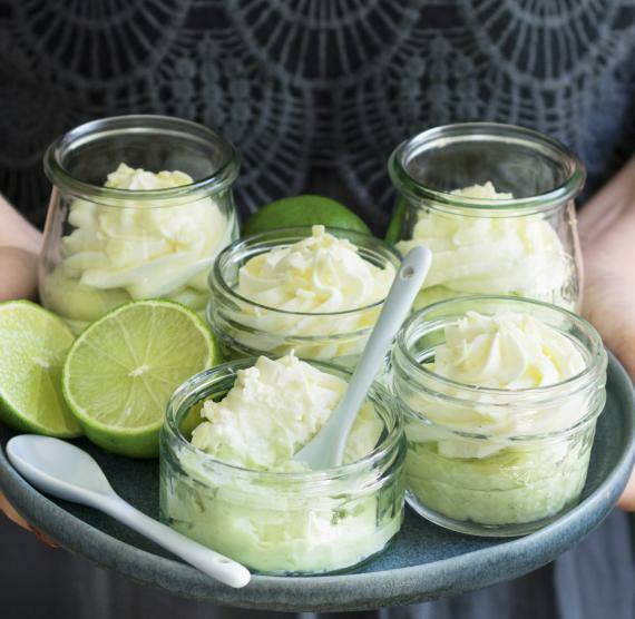 Frau hält Teller mit Cheesecakes im Glas