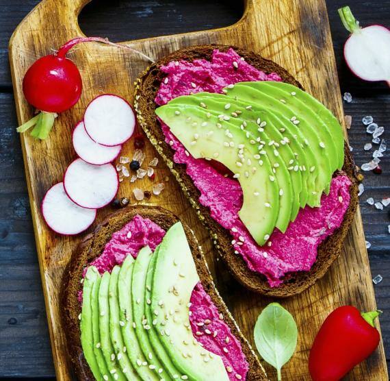 Zwei Brote mit Rote Bete und Avocado auf Brett