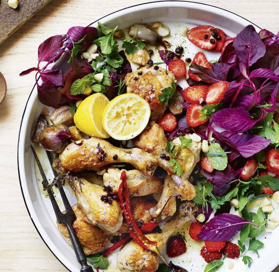 Brett mit Schale und Teller mit Huhn und Salat