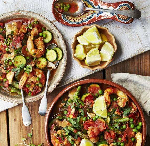 Paella in Schallen auf Holztisch