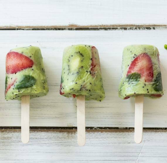 Eis am Stiel auf einem Holzuntergrund mit einer Erdbeere