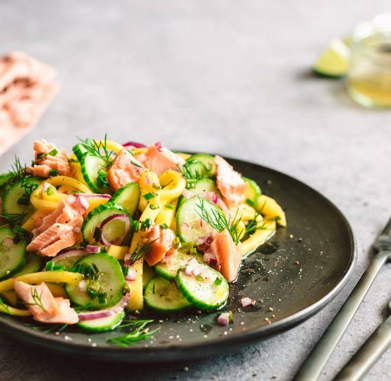 Salat mit Lachs auf einem dunklen Teller