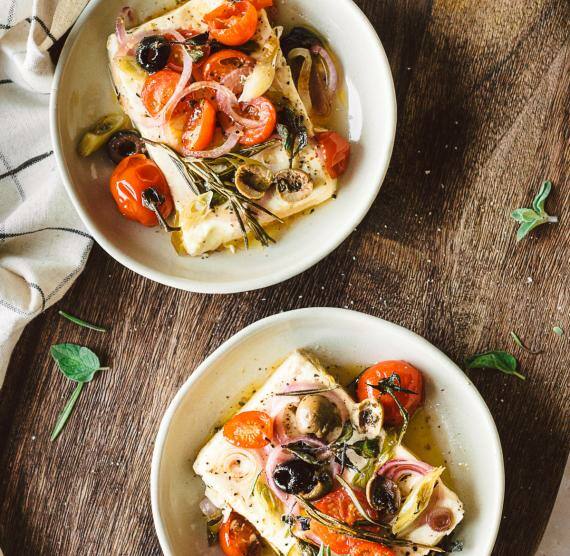 Feta in zwei Schälchen auf einem Holzbrett