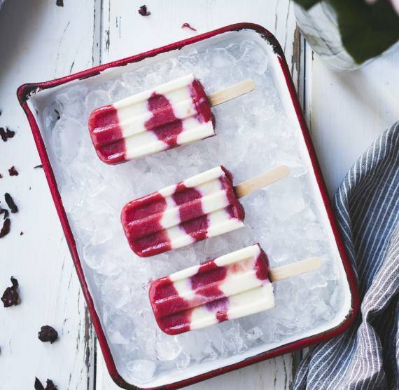 Rot-weißes Eis am Stiel auf Eiswürfeln in einer Form