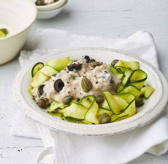 Weißer Teller mit Zucchini-Nudeln und Sauce
