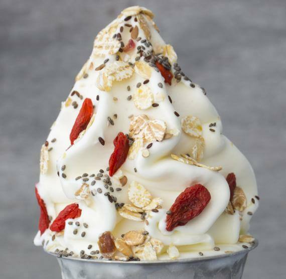 Frozen Yogurt in einem Metallbecher mit Chiasamen, Müsli und Gojibeeren