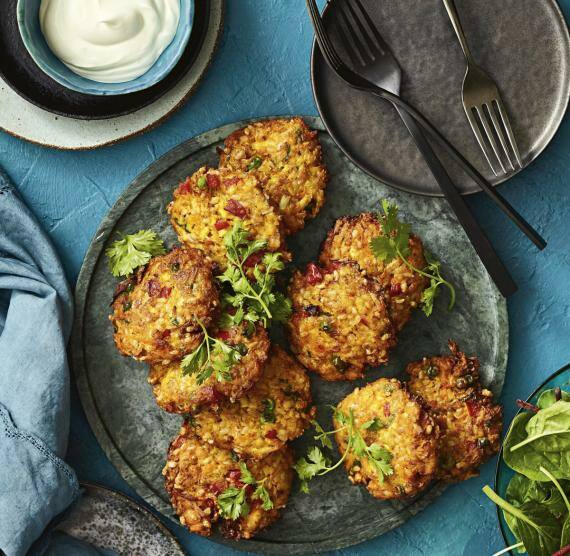 Teller mit Gemüsepuffern und Joghurt in Schale