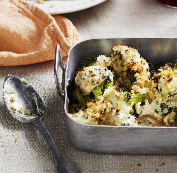 Auflauf auf einem Tisch mit Teller, Gläsern, Tuch und Löffel