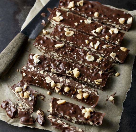 Schoko-Erdnussriegel auf Backpapier und Messer