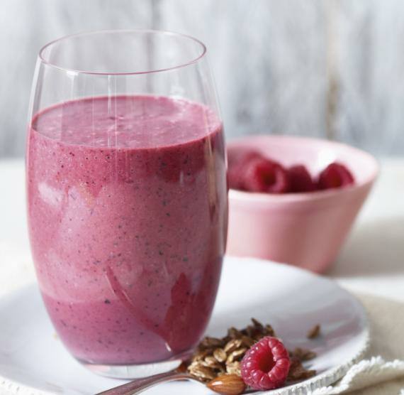 Smoothie in einem Glas mit Himbeeren in einer Schale