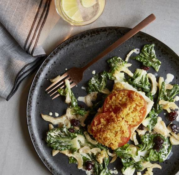 Teller von oben mit Fischfilet und Bröselkruste, drum herum Brokkoliröschen, Mangold und Cranberries
