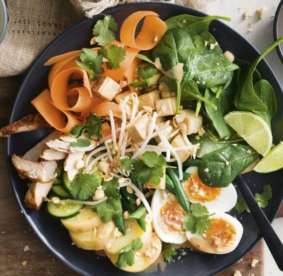 Schwarze Schalen mit Gemüse und kleine Schale Erdnusssauce