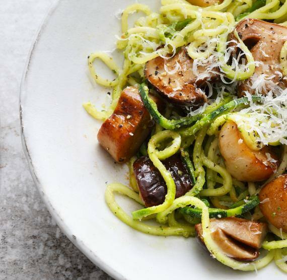 Zucchini-Nudeln mit Pilzen in einerm weißen Teller