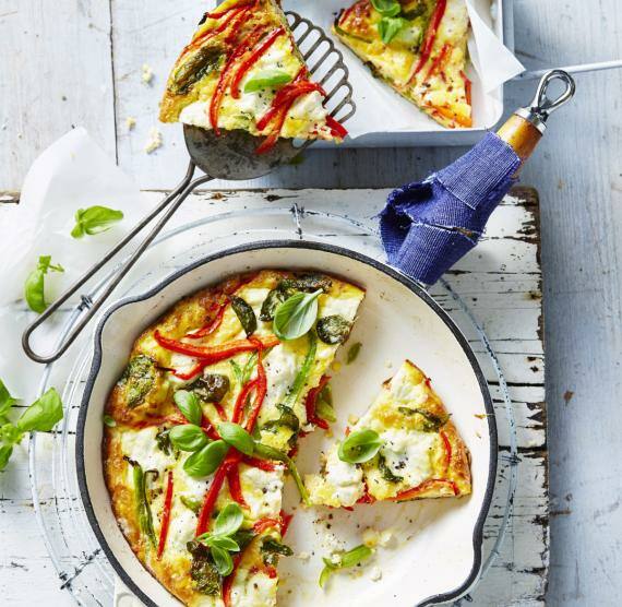 Helle Pfanne mit Frittata mit roter und grüner Paprika, Ricotta und Basilikumblättern