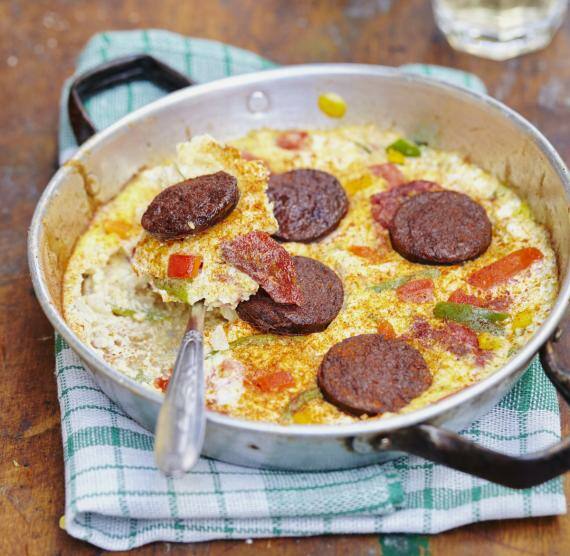 Omelett in einer Pfanne mit Salamischeiben und Paprika