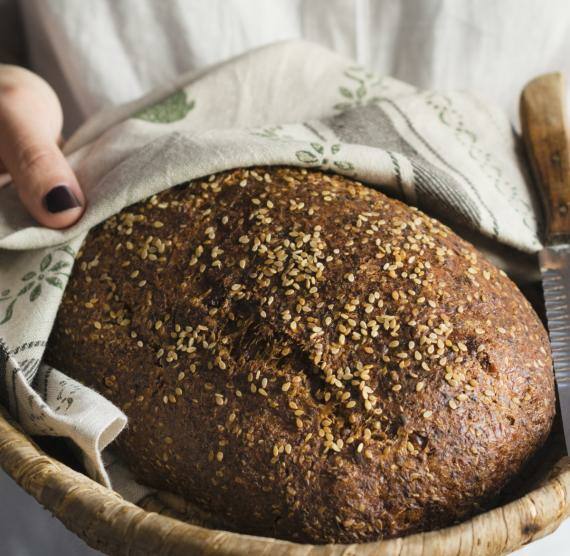 Frau hält Korb mit Brot in die Kamera