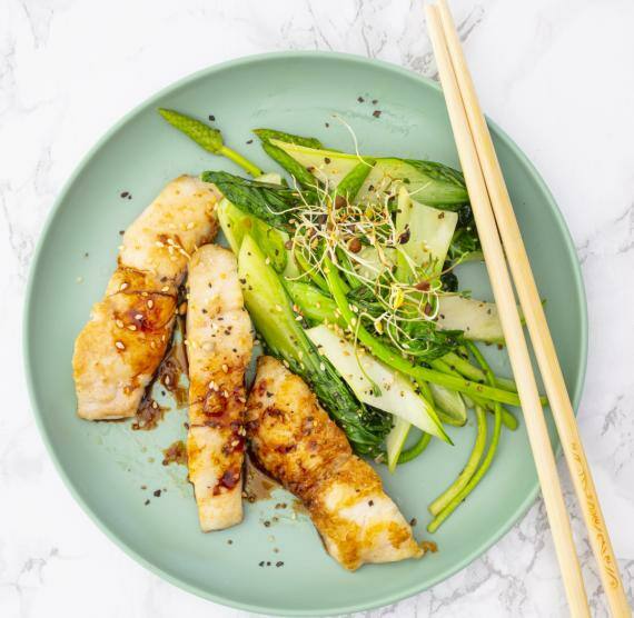 Teller mit Fisch, Pak Choi, Spargel, Sprossen und Stäbchen