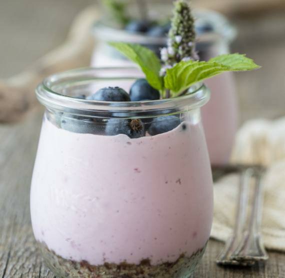 Käsekuchen in kleinen Gläschen mit Blaubeeren und Minze dekoriert