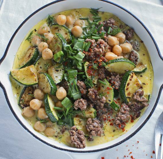 Weiße Pfanne mit Omelett, Hackfleisch, Kichererbsen, Zucchinischeiben, Bärlauch, Schnittlauch und Dill