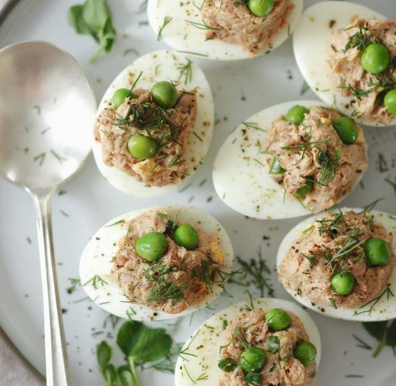 Gefüllte Eier mit Thunfisch und Erbsen auf Teller und Löffel