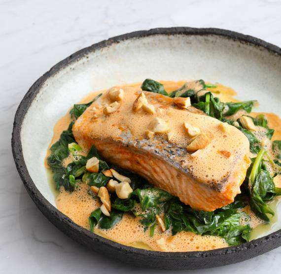 Lachs auf Spinat angerichtet in einem Steingut-Teller