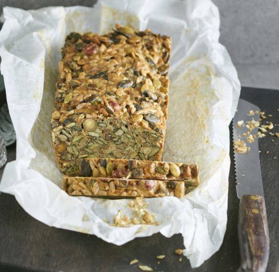 Nussbrot in Backpappier auf Brett mit Messer