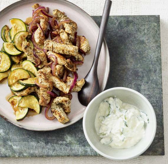 Puten-Gyros mit Zucchini auf einem Teller, auf grüner Mamorplatte