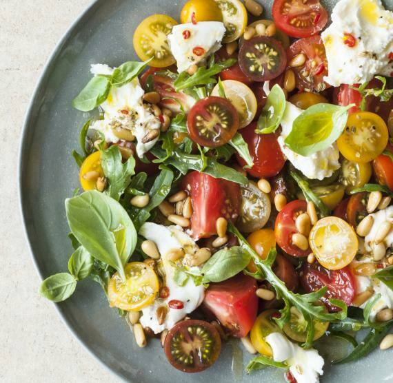 Bunter Tomatensalat mit Burrata in einem hellblauen Teller