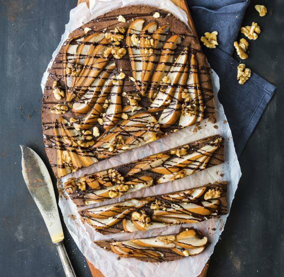 Angeschnittene Birnen-Galette von oben mit Schokosauce auf dunklem Hintergrund