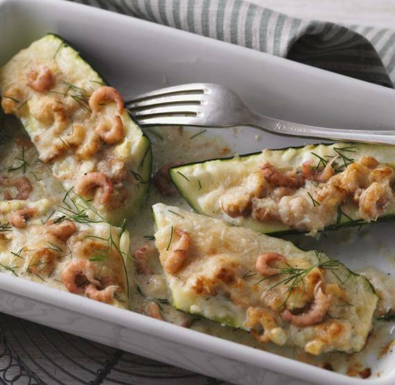 Zucchinihälften mit Krabben und Käse gefüllt in einer Auflaufform