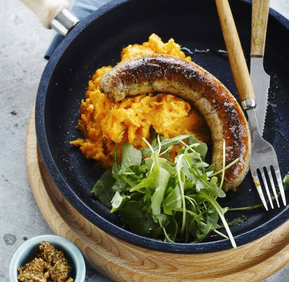 Pfanne mit Püree, Bratwurst, Rucola und Besteck
