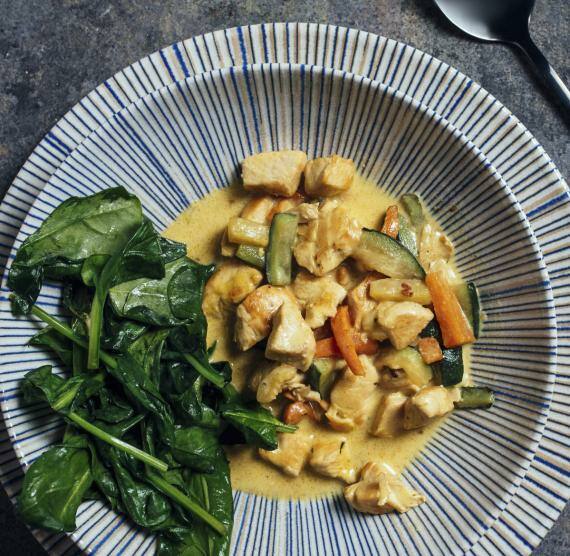 Teller mit Hähnchen-Kokos-Curry, Zucchini, Möhren und Spinat