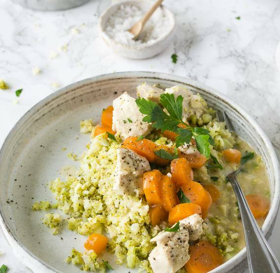 Hühnerfrikassee mit Brokkoli mit Blumenkohl-Reis auf Teller
