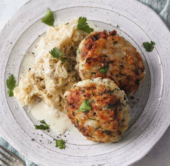 Fischfrikadellen neben Sauerkraut auf einem Teller
