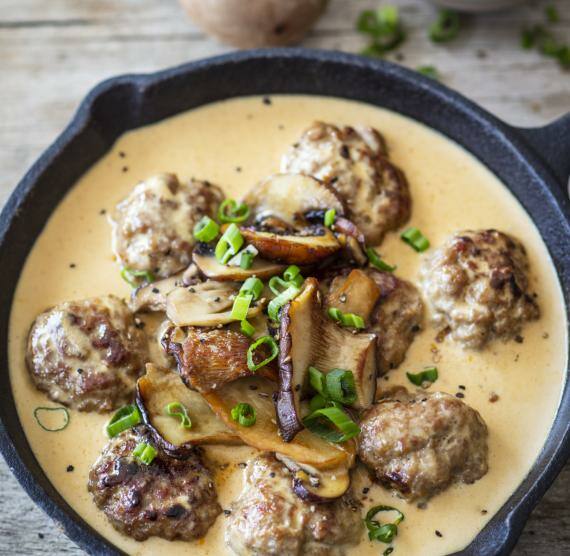 Pfanne mit Kötbullar mit Sauce und Pilzen