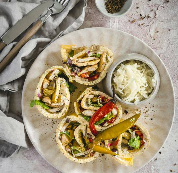 Gyros-Rolle aufgeschnitten auf einem Teller mit Krautsalat und Peperoni