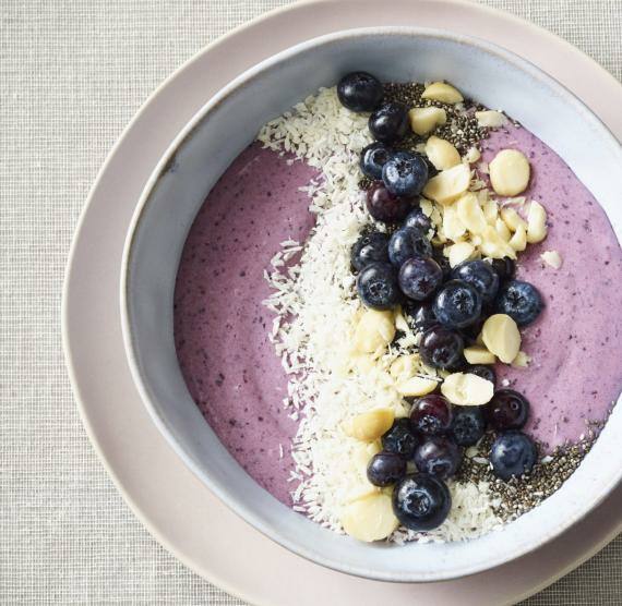 Smoothie-Bowl in einer Schüssel, die auf einem Teller serviert wird
