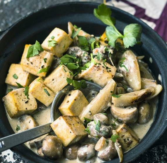 Topf mit Tofu und Champignons in heller Sauce, darüber Petersilie
